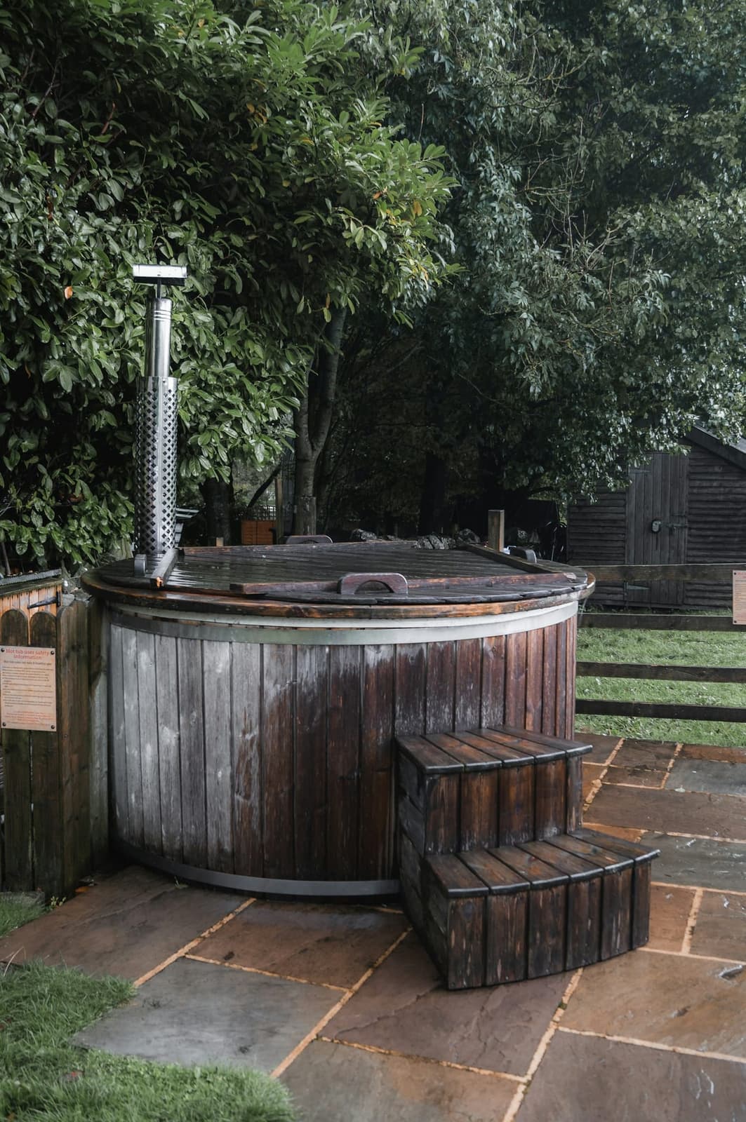 Jacuzzi nordique en bois installé sur un patio extérieur d'un Airbnb rural