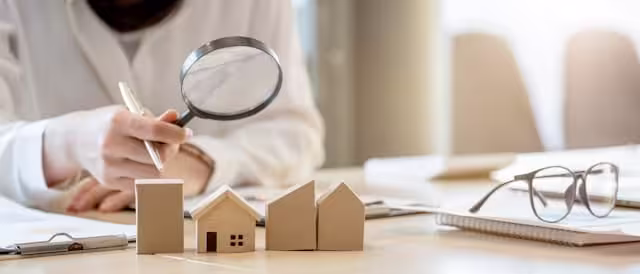 Analyse de dossier immobilier avec loupe et maquette